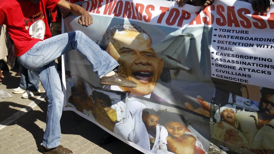 Protestant kope do plaktu s obliejem Baracka Obamy na protest proti jeho nvtv v JAR