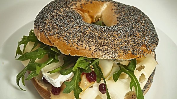 Makový bagel s variací sýrů, rukolou a brusinkami v Nenápadném bistru.