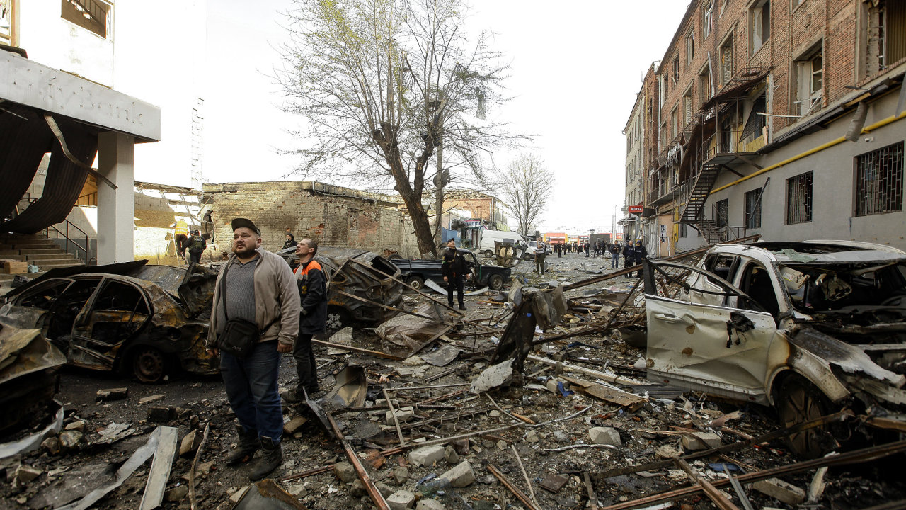 Obyvatelé jedné z ulic v centru Charkova nevìøícnì procházejí ruinami po ruském raketovém útoku.